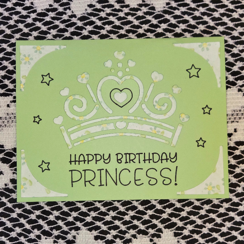 Green birthday card with a princess tiara design and 'Happy Birthday Princess!' text on a textured surface.