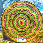 Colorful beaded rainbow design on a textured surface with a blurred natural background