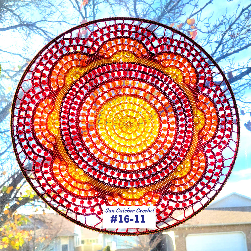 Circular sun catcher with red, orange, and yellow colors against a blurred outdoor background