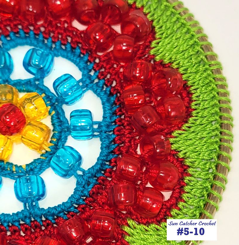 Colorful crocheted sun catcher with red, blue, and green yarn on a white background.
