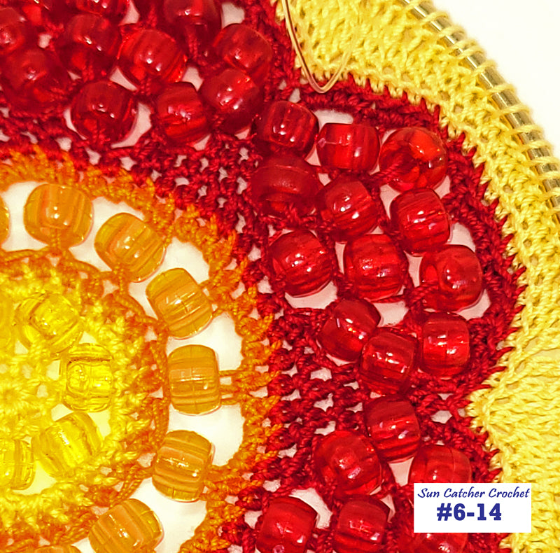 Close-up of red and yellow crochet pattern with 'Sun Catcher Crochet' label.
