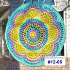 Colorful crochet sun catcher with 'Sun Catcher Crochet' label and number #12-06 in front of a house.