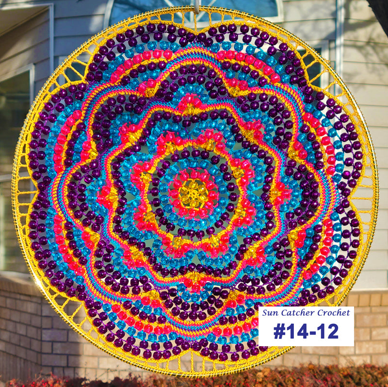 Colorful crocheted sun catcher with a spiral pattern in front of a house.