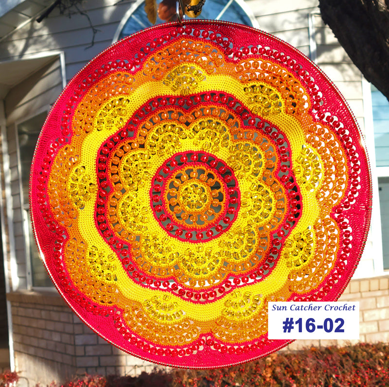 Circular sun catcher with colorful pattern in front of a house