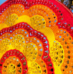Close-up of a colorful woven basket with red, yellow, and orange patterns.