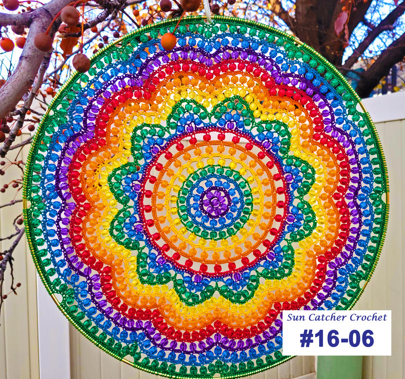 Colorful circular sun catcher with a tree and white fence in the background