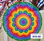 Colorful circular sun catcher with a tree and white fence in the background