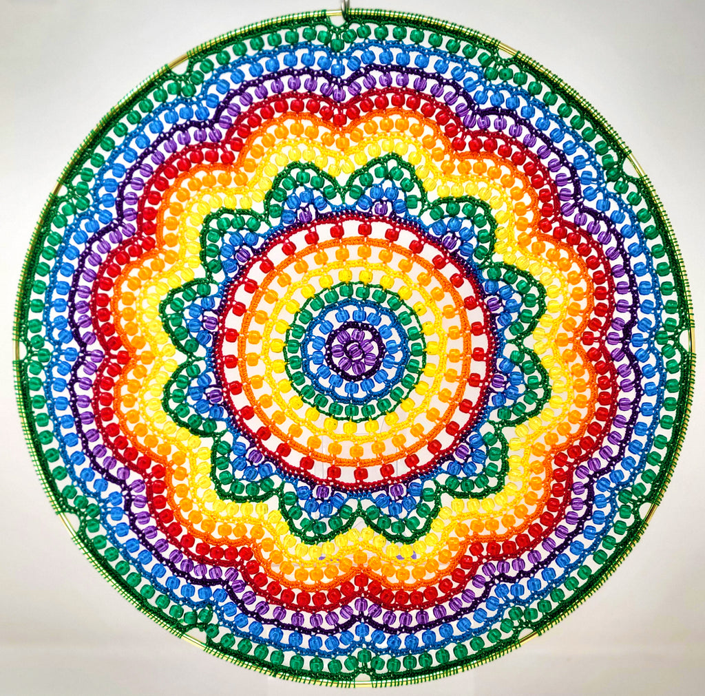 Colorful beaded mandala with a rainbow pattern on a white background