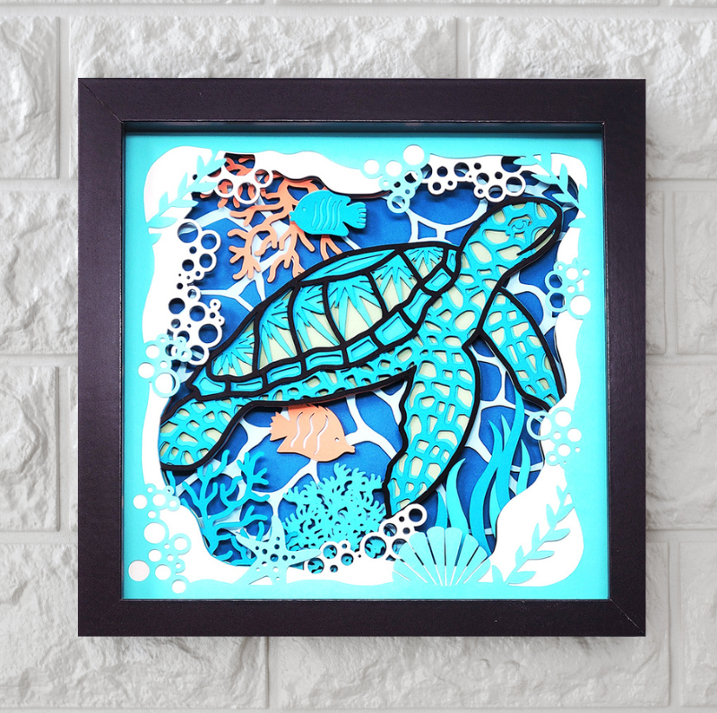 Framed artwork of a turtle and fish in an underwater scene on a textured wall.