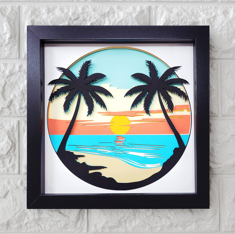 Framed artwork of a tropical sunset with palm trees on a white brick wall.