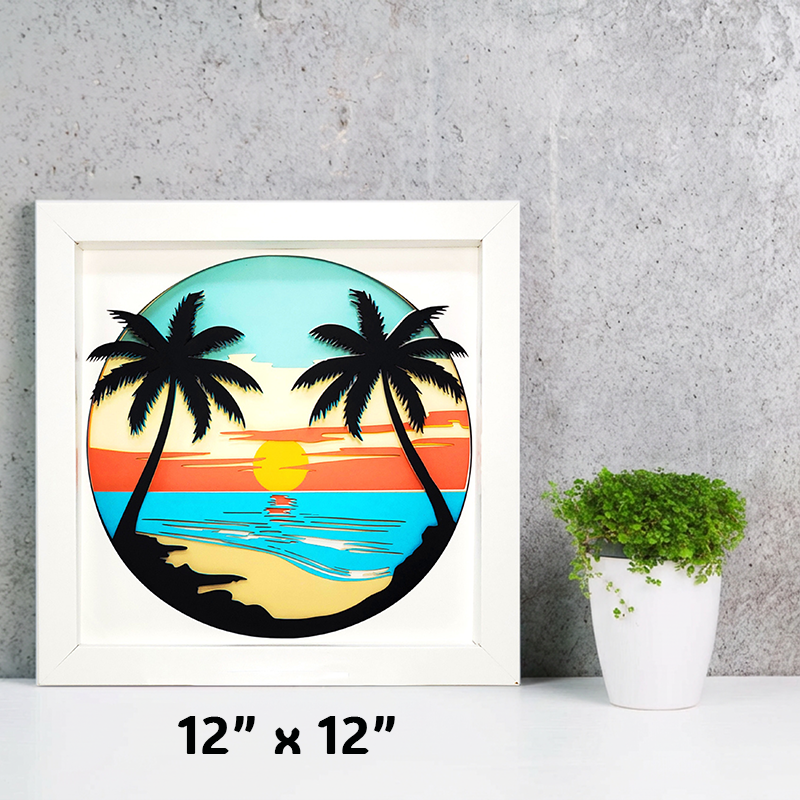 Framed artwork of palm trees and a sunset over water on a gray wall with a plant.
