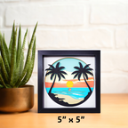 Framed artwork of palm trees and a sunset on a white wall with a plant to the left.