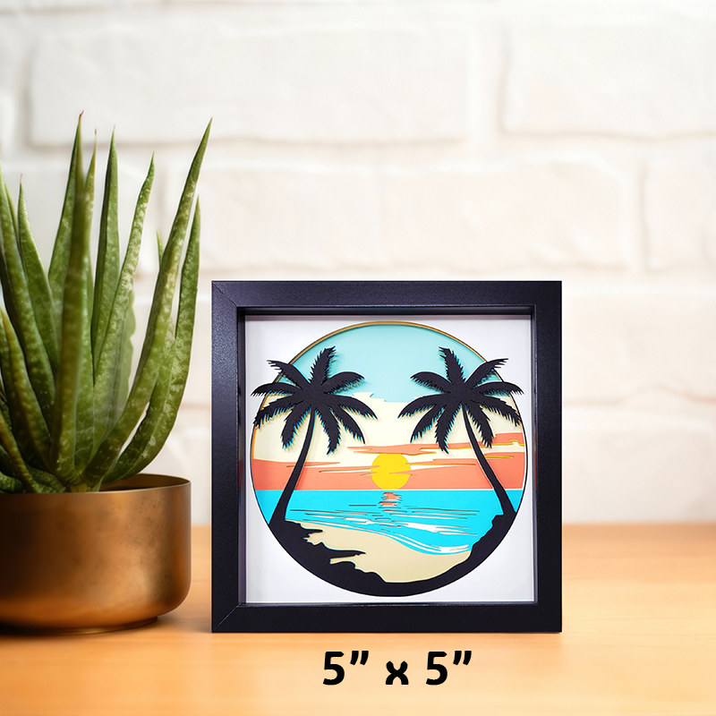 Framed artwork of palm trees and a sunset on a white wall with a plant to the left.