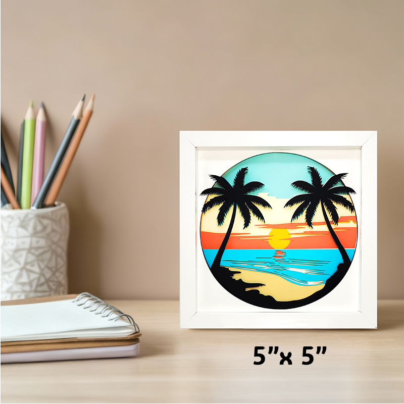 Framed artwork of a tropical sunset with palm trees on a desk with stationery items.