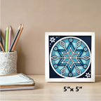 Framed blue geometric design on a desk with stationery items