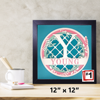 Framed artwork with 'Y YOUNG' design on a desk with stationery items.