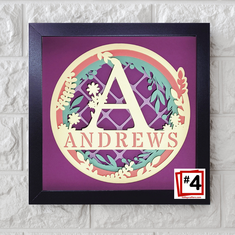 Decorative wall art with a stylized letter 'A' and the name 'ANDREWS' on a purple background, framed in black.