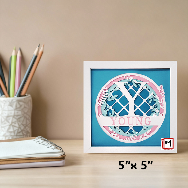 Framed decorative item with 'YOUNG' text on a desk with stationery items.