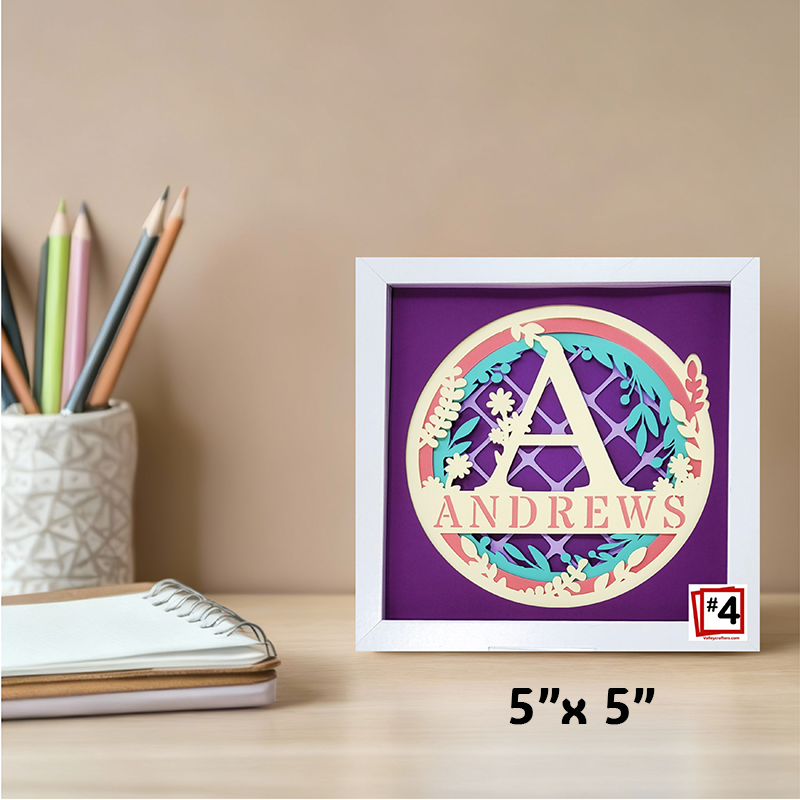 Decorative framed item with 'ANDREWS' on a desk with stationery items.