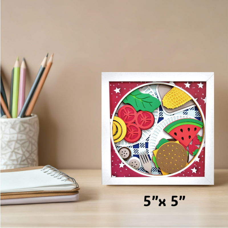 Framed artwork of food items on a desk with stationery