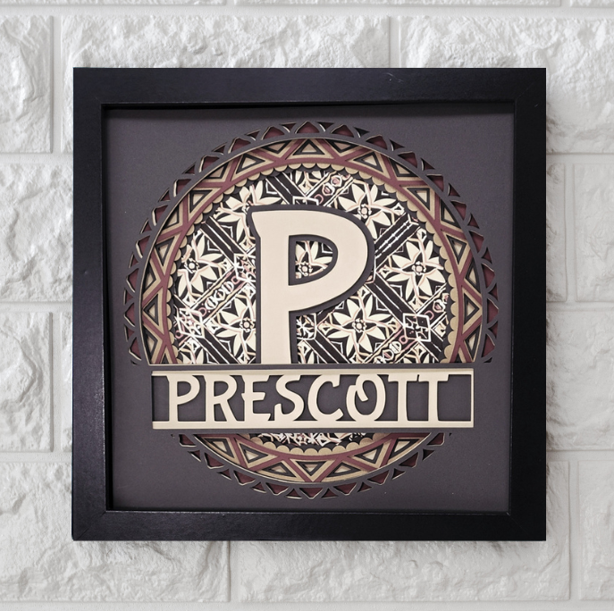 Decorative wall art with a stylized 'P' and 'Prescott' text in a black frame on a textured white wall.