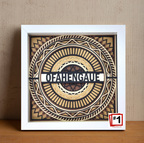 Decorative wall art with geometric design and text on a wooden surface.