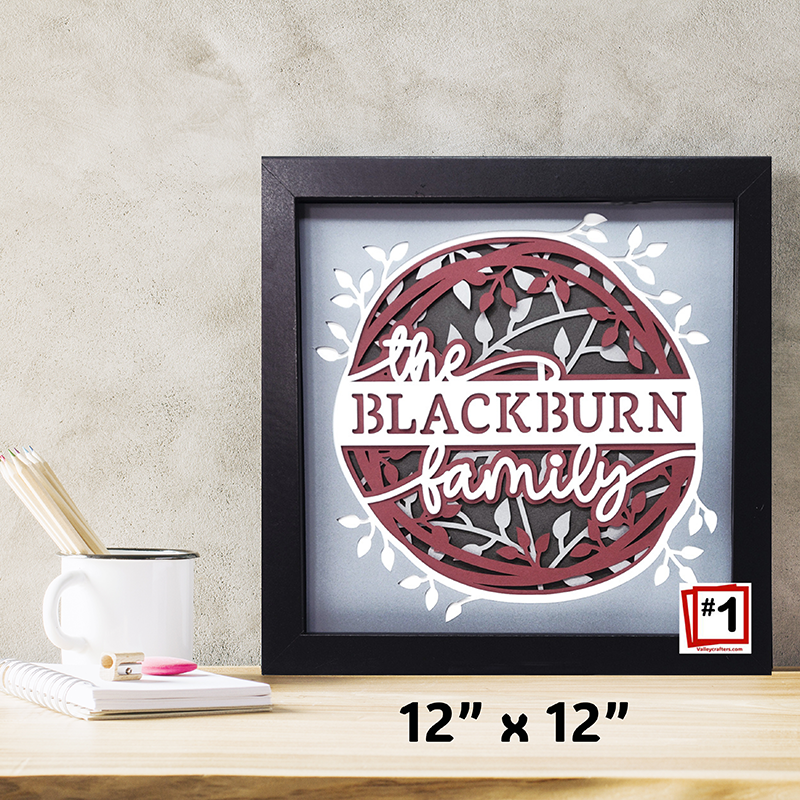 Framed artwork with 'the Blackburn family' design on a desk.