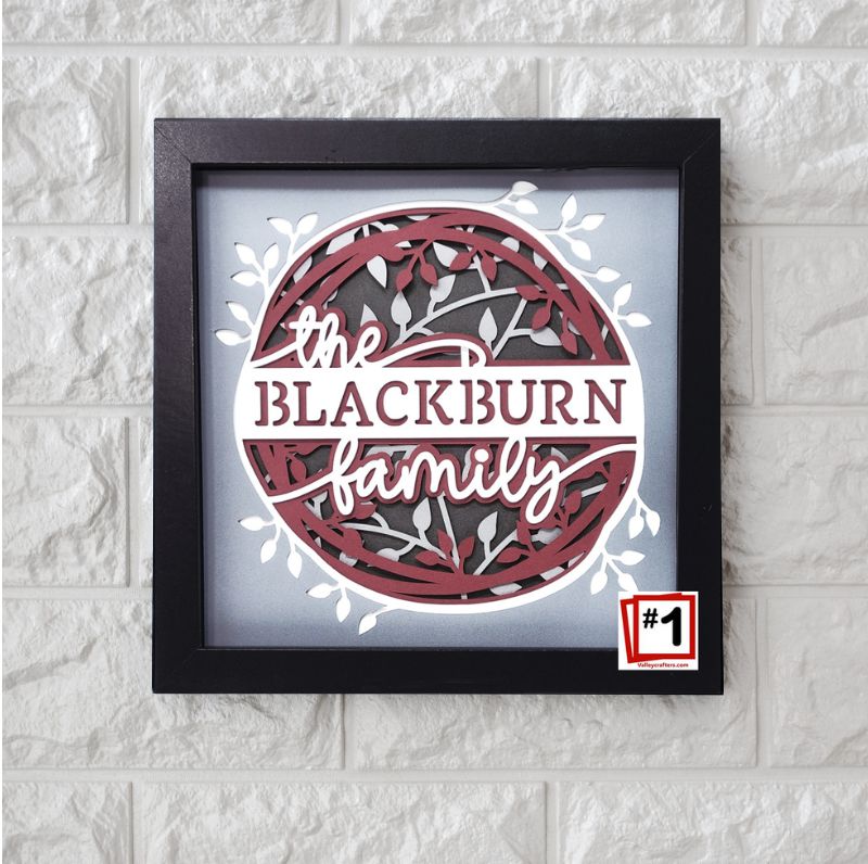 Framed artwork with 'the Blackburn family' text on a textured wall.