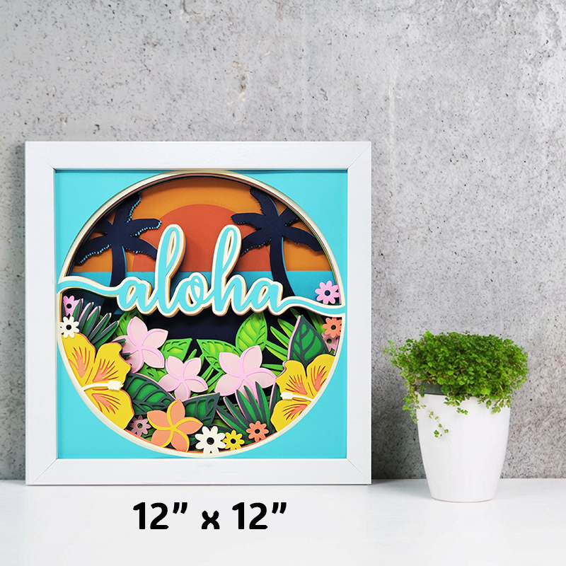 Framed artwork with 'aloha' text and tropical design on a gray wall.