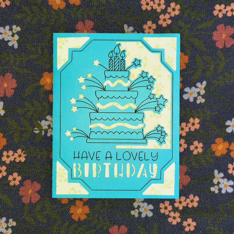 Greeting card with birthday cake illustration and 'Have a lovely birthday' text on a floral background.
