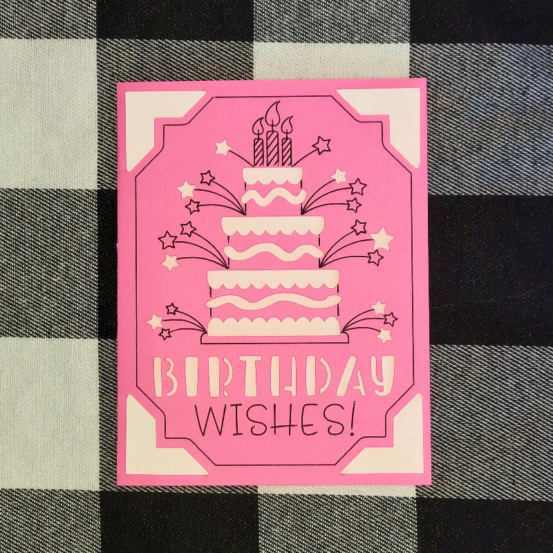 Pink birthday card with cake illustration and 'Birthday Wishes!' text on a checkered background