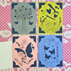 Four decorative cards with floral and butterfly designs on a patterned background.