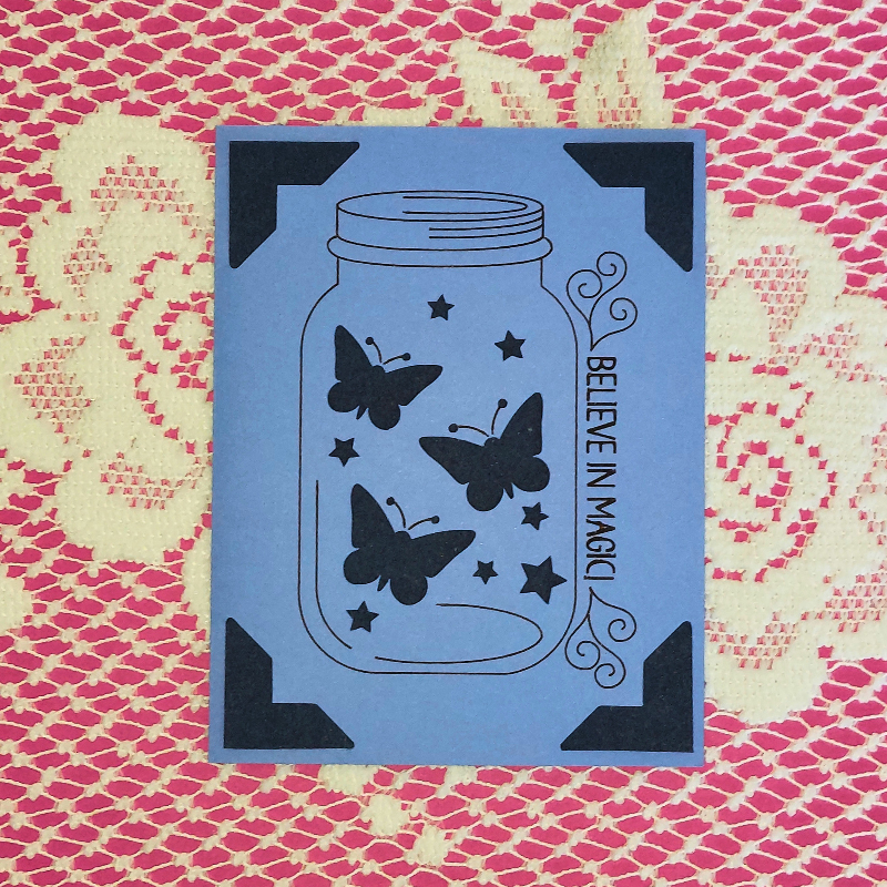 Blue card with butterfly design and 'Believe in Magic' text on a patterned background