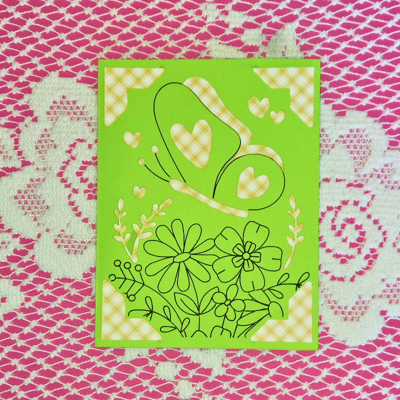 Green card with floral and heart designs on a pink and white patterned background