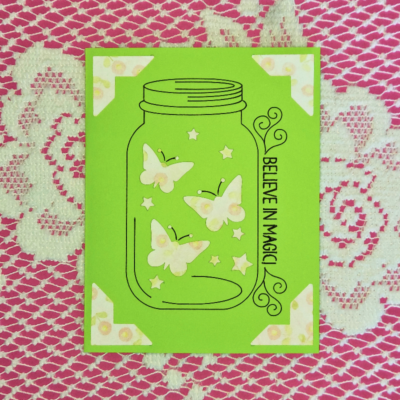 Green card with butterfly design and 'Believe in Magic' text on a patterned background
