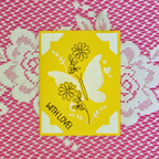 Yellow card with butterfly and floral design on a pink lace background
