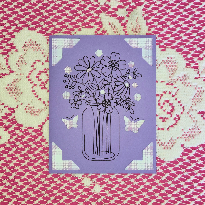 Purple card with floral design on a patterned background