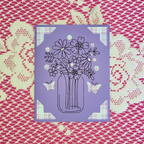 Purple card with floral design on a patterned background