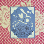 Decorative card with heart and floral design on a patterned background