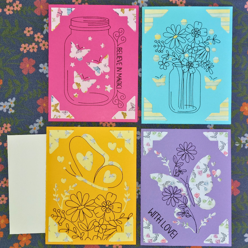 Four colorful greeting cards with butterfly and floral designs on a floral background.