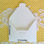 White envelope with measurements on a yellow and white patterned background