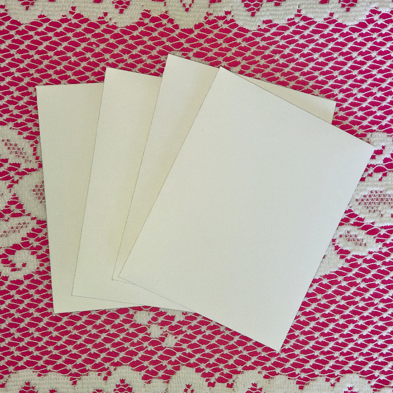 Three white envelopes on a pink and white textured fabric background