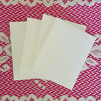 Three white envelopes on a pink and white textured fabric background