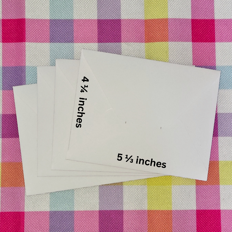 Four envelopes with measurements on a checkered fabric background