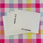 Four envelopes with measurements on a checkered fabric background