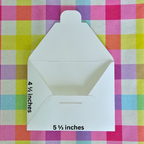 White envelope with measurements on a colorful checkered background