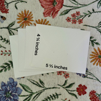 Four envelopes with measurements on a floral fabric background