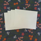 White cards on a floral-patterned fabric background