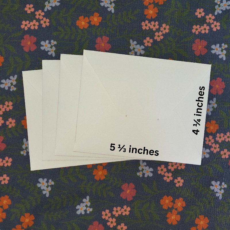 White envelopes with measurements on a floral-patterned fabric background