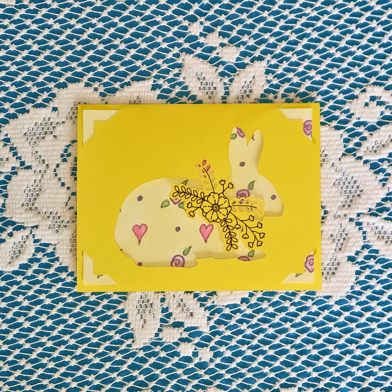 Yellow card with a rabbit design on a textured blue and white background